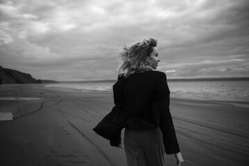 from behind portrait of a woman running along the coast