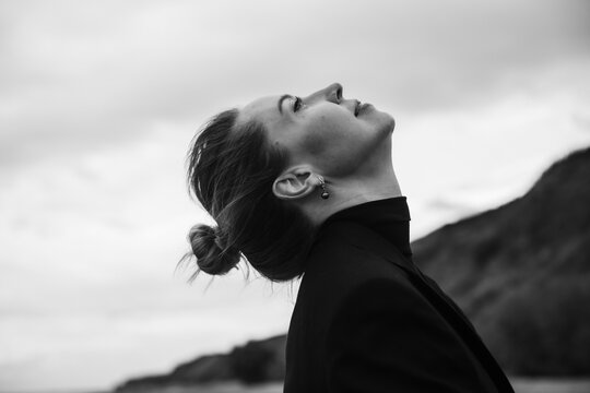 bw side view portrait of a beautiful woman looking at the sky