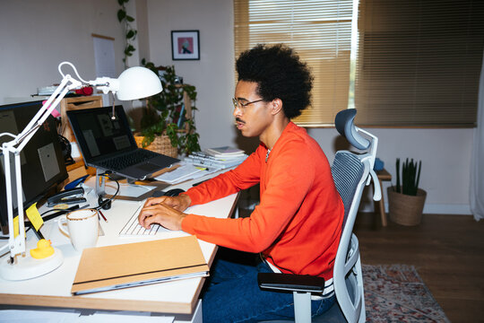 Mixed race freelancer using computer in workplace
