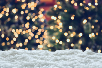Fototapeta na wymiar Empty white snow with blur Christmas tree with bokeh light background