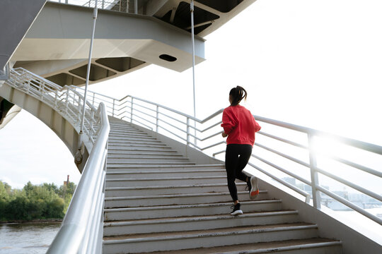 Athletic woman running up stairs during cardio
