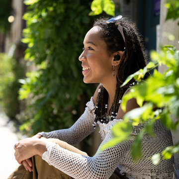 Square portrait of happy young woman listening to music