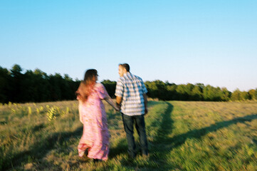Lo-fi blurred portrait of a walking couple at sunset