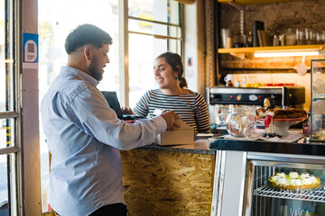 Man in coffee shop buying cake