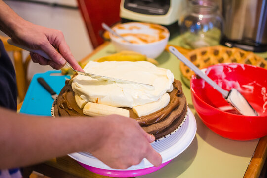 Baker spreading cream in cake