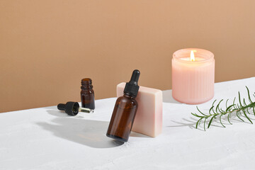 Photo of serum bottle, candle and handmade soap bar on concrete