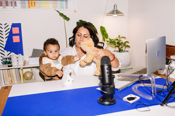 Mom blogger playing with baby in office