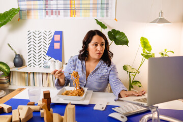 Woman eating noodles at office