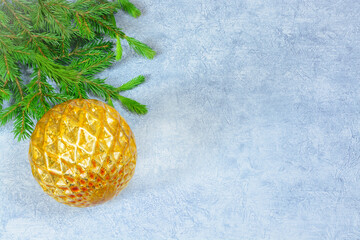 Light gray background with copy space with fir branch and golden christmas ball