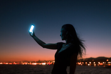 Happy woman taking selfies at sunset
