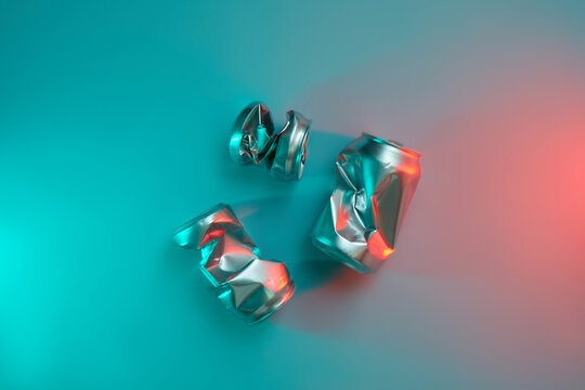 Compressed tin cans on colorful neon background.