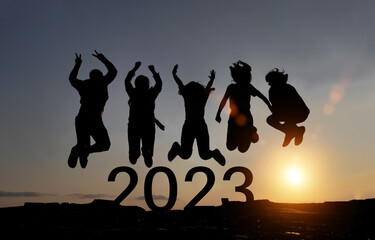 Happy group of people celebrate jump for new year 2023. concept for win victory. silhouette of...