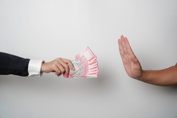 A portrait of businessman refusing money, Indonesian rupiah bills - anti-bribery and corruption...