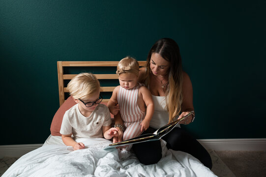 A mother reads a book with her children