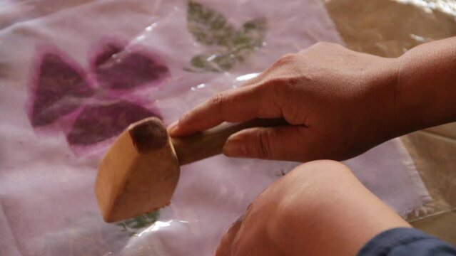 ecoprint printing process video. make a leaf pattern on the fabric. by hitting it with a hammer made of wood. Indonesian craft art.