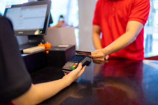 Customer making wireless or contactless payment using credit card. Cashier accepting payment over nfc technology.