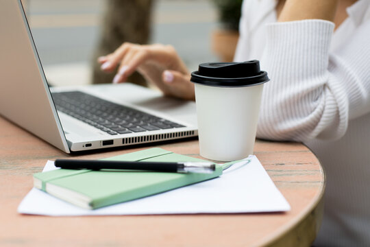 Woman working on laptop on cafe terrace
