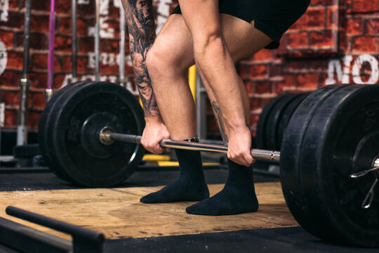 Unrecognizable man training deadlift in the gym