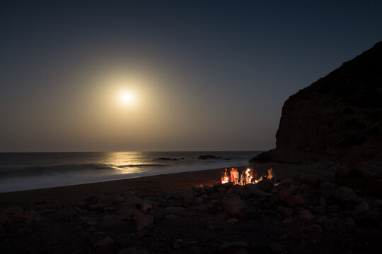 Group of friends during night dinner at the beach