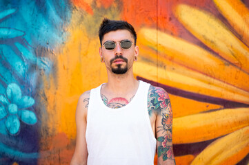 Graffiti artist portrait in front of mural they are painting