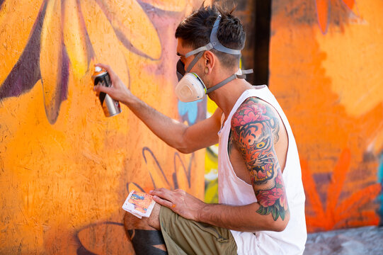Graffiti artist painting large floral mural