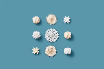 Paper Christmas ornaments on blue background.