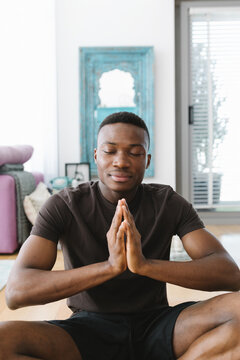 A young man doing meditation at home.