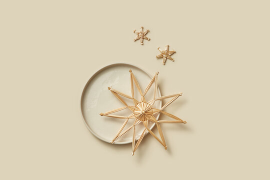Handmade straw stars on stylish ceramic plate.