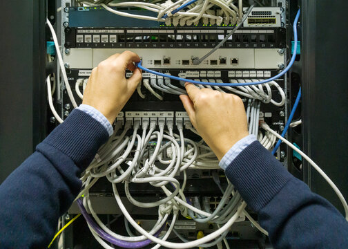 IT professional employee working in a telecom rack