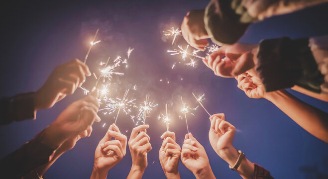 Group Of Young Friends Enjoy With Burning Sparkler In Hands Together