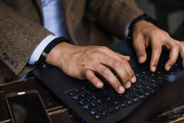 Latino business man hands in keyboard close up