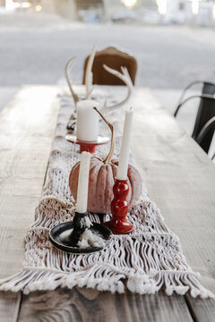 handmade candlesticks and natural elements decorate a fall table