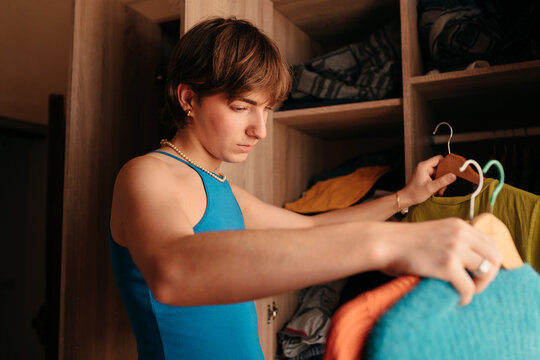 Queer teen organizing his wardrobe