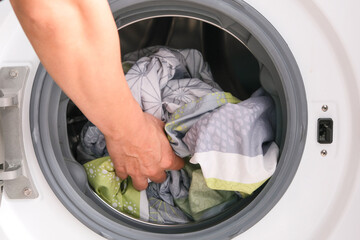 Woman's hand Pick up clothes Washing machine. Clean and Healthy Concepts.