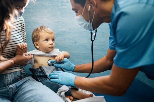 Doctor examining girl with stethoscope in hospital
