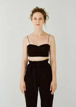 Portrait of a woman in a black tank top and black pants.