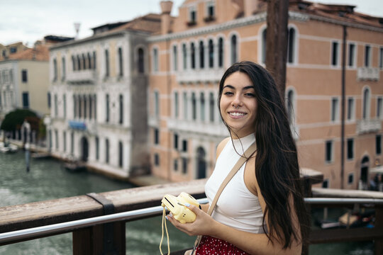 Young woman taking photos in Venice with an instant polaroid camera