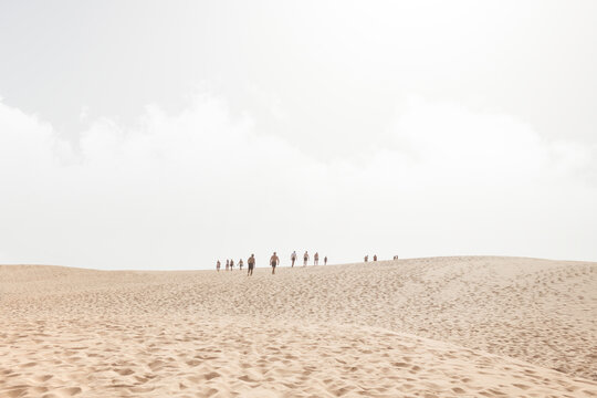 Distant people silhouettes walking on the desert