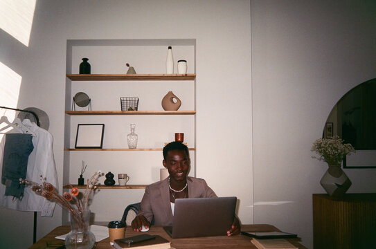 Serious man typing on netbook at table