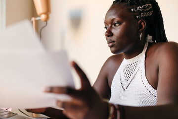 Focused black woman looking at paperwork