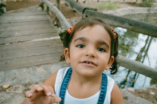 brunette girl with pigtails look at the camera with surprised face