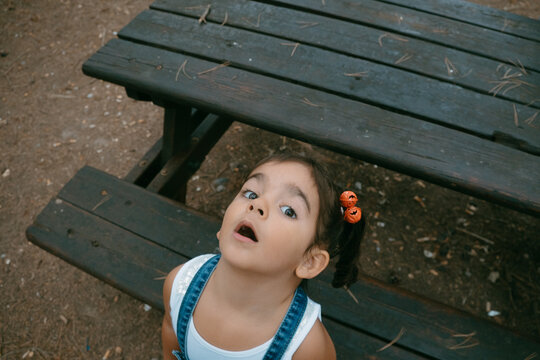 brunette girl with pigtails look at the camera with surprised face