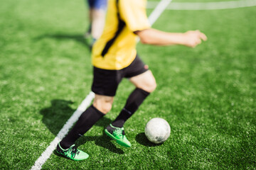 Soccer player with yellow uniform on the green grass