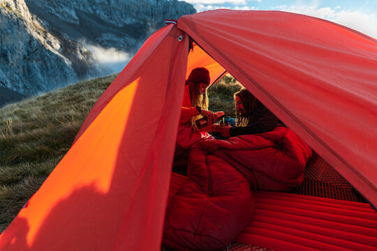 Hikers having breakfast into tent
