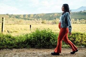 Portrait of a young pregnant woman walking outdoors