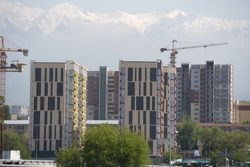 Fototapeta premium Almaty, Kazakhstan - 04.26.2022 : Construction of a high-rise residential complex near a road junction.