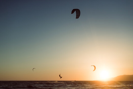 Man silhouette practicing kitesurf at sunset