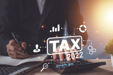 Tax 2022 of Individual income paid and corporations concept. Businessman using a calculator and laptop (notebook) of Data analysis, Paperwork, financial research, and report.
