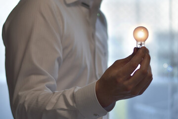 電球を持っている男性 ひらめきのイメージ