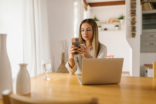 Businesswoman using smartphone at home